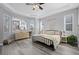 Bright bedroom featuring tray ceiling, multiple windows, and wood flooring at 20272 Terrace View Dr, Parker, CO 80134