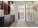 Bathroom with dual vanity sinks, a walk-in closet, and a tiled shower with glass door at 13456 Via Varra # 428, Broomfield, CO 80020