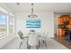 Bright dining room featuring glass table, seating for six, modern chandelier, and view at 13456 Via Varra # 428, Broomfield, CO 80020