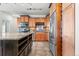 Close up of kitchen featuring wood cabinets, granite countertops, wine storage, and stainless appliances at 13456 Via Varra # 428, Broomfield, CO 80020