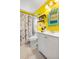 Bright bathroom with yellow walls, white vanity and paris themed shower curtain at 14595 Robins Dr, Denver, CO 80239