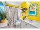 Bright bathroom with yellow walls, white vanity and paris themed shower curtain at 14595 Robins Dr, Denver, CO 80239
