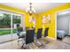 Bright dining area with a glass table, seating for six, and sliding doors to the back yard at 14595 Robins Dr, Denver, CO 80239