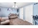 Bright living room with neutral carpet, modern lighting, and a comfortable seating area at 14595 Robins Dr, Denver, CO 80239