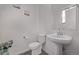 Elegant half-bathroom featuring a pedestal sink, modern toilet, and neutral decor at 515 Bridger Ave, Fort Lupton, CO 80621