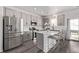 Modern kitchen with stainless steel appliances, gray cabinets, and a quartz countertop island at 515 Bridger Ave, Fort Lupton, CO 80621