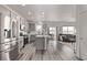 Bright, open kitchen with stainless steel appliances and a center island with seating, flowing into the living room at 515 Bridger Ave, Fort Lupton, CO 80621
