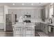 Well-lit kitchen boasts island seating, stainless steel appliances, and stylish gray cabinetry at 515 Bridger Ave, Fort Lupton, CO 80621