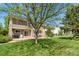 The backyard has a lush lawn with a patio, outdoor seating, and mature trees at 17332 E Lake Ln, Aurora, CO 80016