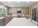 Bright kitchen features stainless appliances, wooden cabinetry, island with seating, and ample counter space at 17332 E Lake Ln, Aurora, CO 80016
