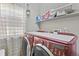 Laundry room features modern red front load washer and dryer with built in countertop at 17332 E Lake Ln, Aurora, CO 80016