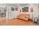 Relaxing living room features hardwood floors, an orange sofa, and lots of art at 17332 E Lake Ln, Aurora, CO 80016