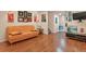 Bright living room with hard wood floors, orange couch and TV with storage at 17332 E Lake Ln, Aurora, CO 80016