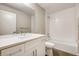 Modern bathroom featuring a white vanity, a large mirror, and a tiled shower-over-tub combination at 2473 S Cherokee St, Denver, CO 80223