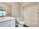 Bright bathroom with white cabinets, stylish fixtures, and a bathtub with white tiles at 2473 S Cherokee St, Denver, CO 80223