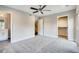 Large bedroom with a ceiling fan, plush carpet, and multiple access points at 2473 S Cherokee St, Denver, CO 80223
