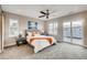 Bright bedroom with a ceiling fan, neutral color scheme, gray carpet, and sliding glass doors at 2473 S Cherokee St, Denver, CO 80223