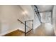 Hallway with modern staircase, black metal railings, wood floors, and neutral walls at 2473 S Cherokee St, Denver, CO 80223