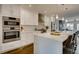 Modern kitchen features white cabinets, stainless steel appliances, and a large center island with bar seating at 2473 S Cherokee St, Denver, CO 80223