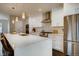 Well-lit kitchen with white cabinets, stainless steel appliances, and a large island with seating at 2473 S Cherokee St, Denver, CO 80223