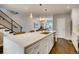 Spacious kitchen with white cabinetry, stainless steel appliances, and an island with barstool seating at 2473 S Cherokee St, Denver, CO 80223