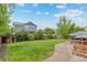 Backyard featuring lawn, mature landscaping, and a stone patio at 10197 Quintero St, Commerce City, CO 80022