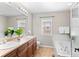 Bright bathroom with double sinks, large mirror, soaking tub, and tiled flooring at 10197 Quintero St, Commerce City, CO 80022