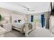 Bright bedroom featuring a white distressed wood bed frame, ceiling fan, and abundant natural light from the window at 10197 Quintero St, Commerce City, CO 80022
