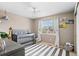 Charming Bedroom featuring a gray crib, striped rug, and plenty of natural light at 10197 Quintero St, Commerce City, CO 80022