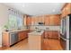 Well-appointed kitchen featuring stainless steel appliances, center island, and wood cabinets at 10197 Quintero St, Commerce City, CO 80022