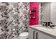 Stylish powder room featuring floral wallpaper, a pink accent wall, and modern fixtures at 7125 Skygazer St, Castle Pines, CO 80108