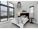 Well-lit bedroom with multiple windows, a queen-sized bed, and decorative light fixture at 7125 Skygazer St, Castle Pines, CO 80108