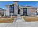 Contemporary home featuring stone accents, a chimney, and a well-manicured front yard at 7125 Skygazer St, Castle Pines, CO 80108