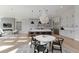 Open-concept kitchen and dining area with modern chandelier, central island, and stainless steel appliances at 7125 Skygazer St, Castle Pines, CO 80108