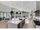 Open living space featuring a modern kitchen, dining area, and living room with large windows and hardwood floors at 7125 Skygazer St, Castle Pines, CO 80108