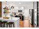 Bright and modern kitchen featuring white cabinets, stainless steel appliances, exposed brick and open shelving at 1452 S Logan St, Denver, CO 80210
