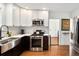 Modern kitchen with stainless steel appliances, white cabinets, contrasting counters and wood flooring at 1452 S Logan St, Denver, CO 80210