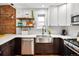 Renovated kitchen with white cabinets, quartz countertops, stainless steel appliances, and exposed brick at 1452 S Logan St, Denver, CO 80210