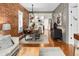 Open living area featuring hardwood floors, exposed brick accent wall, modern furniture, and bright lighting at 1452 S Logan St, Denver, CO 80210