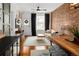 Well-lit living room with an exposed brick wall, modern furniture, and hardwood floors at 1452 S Logan St, Denver, CO 80210