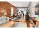 Open-concept living area featuring exposed brick, wood floors, and a seamless flow to the kitchen at 1452 S Logan St, Denver, CO 80210