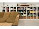 Bright living room view of built-in shelving displaying books and décor, complemented by a tan sofa at 1452 S Logan St, Denver, CO 80210