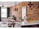 Living area featuring an exposed brick wall, modern light fixture and an open floorplan perfect for entertaining at 1452 S Logan St, Denver, CO 80210