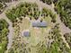 Aerial view showing the home and property surrounded by mature trees and winding roads at 31551 Black Widow Dr, Conifer, CO 80433