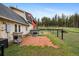 Backyard view of home with barn, fenced yard, patio with grill, hot tub, and lush lawn at 31551 Black Widow Dr, Conifer, CO 80433