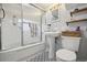 White bathroom with black and white tile, walk-in shower, modern sink, and open shelving at 31551 Black Widow Dr, Conifer, CO 80433