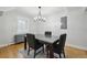 Simple dining room with modern light fixture, wood flooring, and dark wood table with upholstered chairs at 31551 Black Widow Dr, Conifer, CO 80433