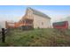 Back of home with multiple decks, hot tub, lawn, and a view of the barn that sits on the property at 31551 Black Widow Dr, Conifer, CO 80433