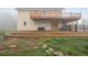Inviting back exterior showing multiple decks and backyard of home with a stone walkway and lush grass at 31551 Black Widow Dr, Conifer, CO 80433