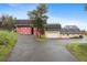 Exterior view featuring a barn and house with mature trees and a driveway at 31551 Black Widow Dr, Conifer, CO 80433